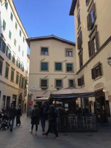 grupa ludzi idących ulicą z budynkami w obiekcie Romantico nido nel cuore di Firenze we Florencji