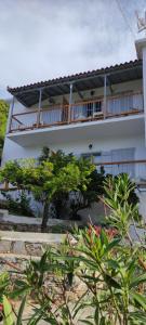 a white building with a tree in front of it at Skalopati Studios & Villa in Panormos Skopelos