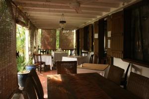 a dining room with a table and chairs and a table and chairsktop at Le Jardin de Beau Vallon in Mahébourg