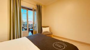 1 dormitorio con 1 cama, 1 silla y 1 ventana en Bicos U by Check-in Portugal, en Albufeira