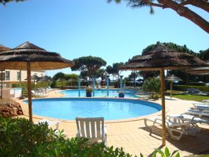 una piscina con sillas y sombrillas en Bicos U by Check-in Portugal, en Albufeira
