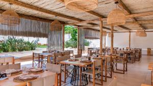 un ristorante con tavoli e sedie in una stanza di Cumeja Beach Club & Hotel a Baia Domizia