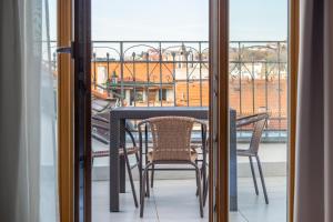 a table and chairs on a balcony with a view at Janackovo - Riverside Residence in Prague