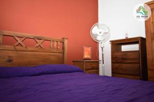 1 dormitorio con cama morada y ventilador en APART CABAÑAS LOS SAUCES in 