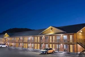 a building with a car parked in a parking lot at Super 8 by Wyndham Whites Creek/ Nashville NW Area in Whites Creek