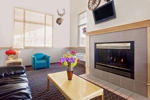 a living room with a fireplace with a vase of flowers at Super 8 by Wyndham Helena in Helena