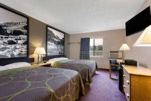 a hotel room with two beds and a flat screen tv at Super 8 by Wyndham Helena in Helena