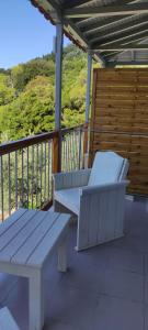 two white benches sitting on a balcony with a view at Skalopati Studios & Villa in Panormos Skopelos