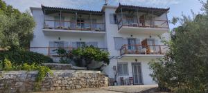 a white house with balconies on the side of it at Skalopati Studios & Villa in Panormos Skopelos