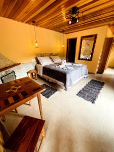a bedroom with a large bed and a wooden ceiling at Pousada Magia da Montanha in Visconde De Maua +107 photos