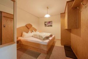 1 dormitorio con 1 cama con cabecero de madera en Appartements-Klaus, en Neustift im Stubaital