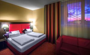 
a hotel room with a large bed and a large window at Best Western Plus Amedia Art Salzburg in Salzburg
