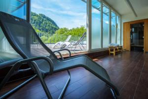 a room with chairs and a balcony with a view at Best Western Plus Amedia Art Salzburg in Salzburg