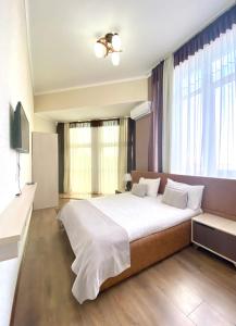 a bedroom with a large bed and a large window at Caravan Hotel in Karakol