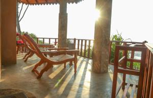 eine Veranda mit einem Tisch und Stühlen auf dem Balkon in der Unterkunft Nature Lanka Ayurveda Resort - All Meals and Ayurveda Treatments with Yoga in Tangalle