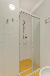 una doccia con porta in vetro in bagno di Hibiscus a Bibione