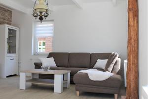 uma sala de estar com um sofá e uma mesa de centro em Tant Berta´s Huus em Krummhörn
