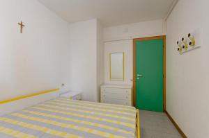 1 dormitorio con cama y puerta verde en Hibiscus, en Bibione