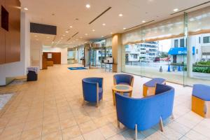 豐川市的住宿－豐川舒適酒店，大楼内带蓝色桌椅的大堂