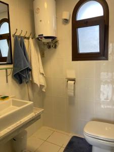een badkamer met een toilet, een wastafel en een raam bij Diar El Rabwa Modern Apartment with Free WiFi and Private Balcony in Sharm El Sheikh