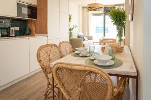 cocina y comedor con mesa y sillas en La Casa del Pintor Apartments, en Sevilla