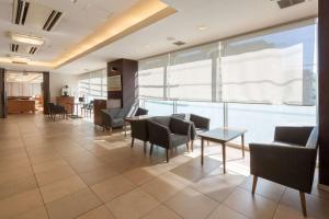 a lobby with chairs and tables and a large window at Comfort Hotel Tokyo Kiyosumi Shirakawa in Tokyo