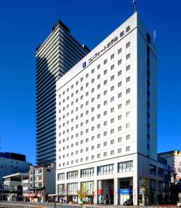 Comfort Hotel Gifu في غيفو: مبنى ابيض كبير عليه لافته