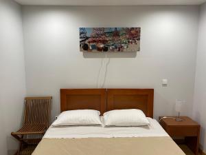 sypialnia z łóżkiem i obrazem na ścianie w obiekcie Bed & Seaside w mieście Nazaré