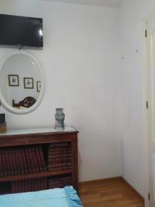 Josefa House في هويلفا: غرفة نوم مع مرآة وخزانة مع سرير