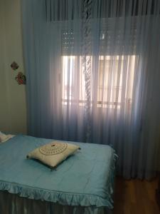 a bed with a pillow in front of a window at Josefa House in Huelva