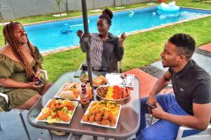 a group of people sitting around a table with food at Clifford's Rufaro Hotel, Conference & Spa in Burgersfort
