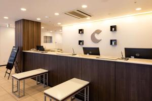 an office with a reception counter with laptops on it at Comfort Hotel Sendai East in Sendai