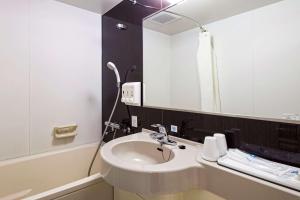 a bathroom with a sink and a mirror at Comfort Hotel Sendai East in Sendai