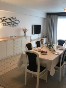 een kamer met een tafel en stoelen en een keuken bij Gezinsappartement - La Plage - Wenduine zeedijk in Wenduine