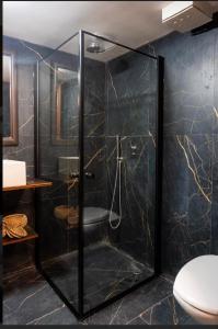 a shower with a glass door in a bathroom at Ofek's place - NOGA in Tel Aviv