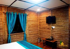 um quarto com uma cama com cortinas azuis e uma janela em Bamboo Junction Resort - Kanatal, Valley & Mountain View em Dhanaulti