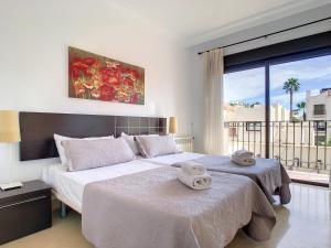 1 dormitorio con 2 camas y ventana grande en Roda Golf Resort - 5309 en San Javier