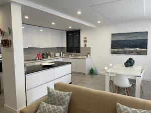 a kitchen and living room with a couch and a table at Salinas House T3 in Tavira