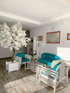 ロオにあるNarayanaの白い椅子と木のあるリビングルーム