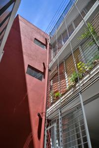 a red building with a balcony on the side of it at Departamento Oroño in Rosario