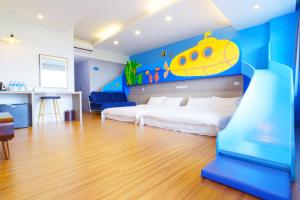 1 dormitorio con 1 cama con un mural submarino amarillo en Two Home Inn, en Hualien City
