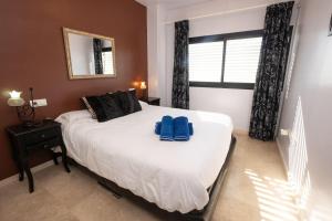 een slaapkamer met een bed met twee blauwe kussens erop bij LAS VISTAS 2C MENYBER in Nerja