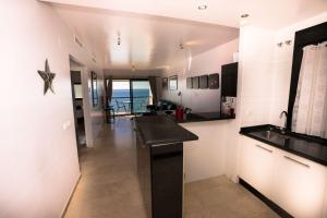 a kitchen with a counter and a view of the ocean at PLAYA DEL SALON 2c MENYBER in Nerja +24 photos