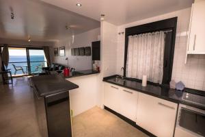 a kitchen with white cabinets and a black counter top at PLAYA DEL SALON 2c MENYBER in Nerja