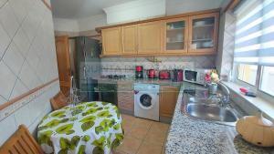 a kitchen with a sink and a washing machine at Apartamento AH in Guia