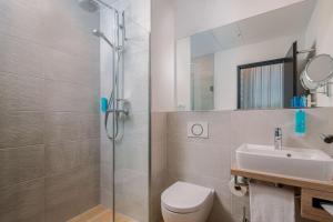 a bathroom with a toilet, shower, and sink at Best Western Hotel Arabellapark Muenchen in Munich