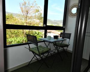 - une table et des chaises dans une chambre avec fenêtre dans l'établissement Le Lobellia à Sainte Clotilde centre, à Sainte-Clotilde