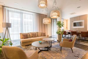 a living room with a couch and chairs and a table at Best Western Hotel Airport Frankfurt in Frankfurt