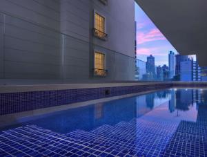 einen Pool mit einer Skyline der Stadt im Hintergrund in der Unterkunft Bristol Panama, a Registry Collection Hotel in Panama-Stadt