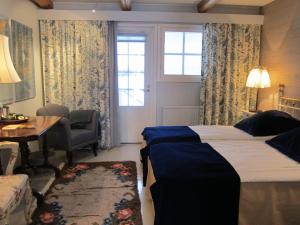 a bedroom with a bed and a desk and a window at Tertin Kartano in Mikkeli